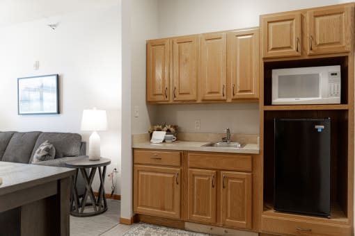 a kitchen with wooden cabinets and a microwave and a sink