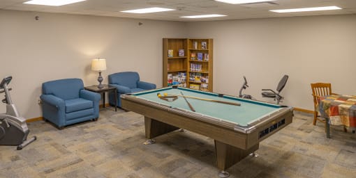 a game room with a pool table and chairs