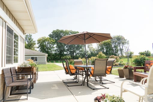 a backyard patio with a table and chairs and an umbrella