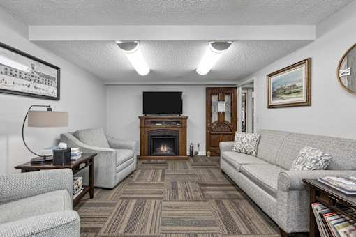A living room with a grey couch, a fireplace, and a television.