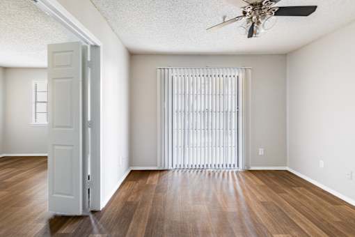 A room with a white door and a window with blinds.