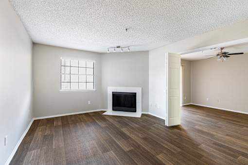 A living room with a fireplace and wood flooring.