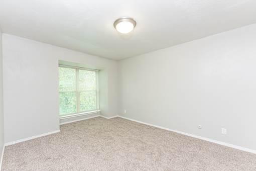 an empty room with carpet and a window