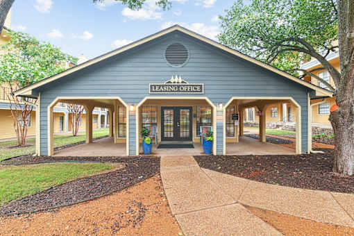 A leasing office building with a blue roof and a sign on the front.