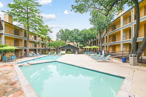 A swimming pool in a courtyard surrounded by apartment buildings.
