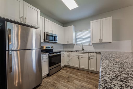 a kitchen with stainless steel appliances and white cabinets