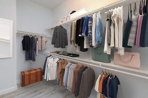 a rack of clothes and bags in a closet