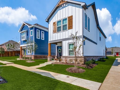 a blue and white house with a sidewalk in front of it