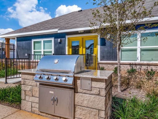 a stainless steel barbecue grill in front of a house