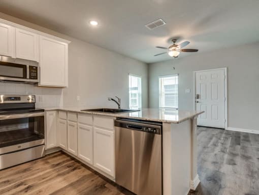 a kitchen with an island and a stove and a ceiling fan