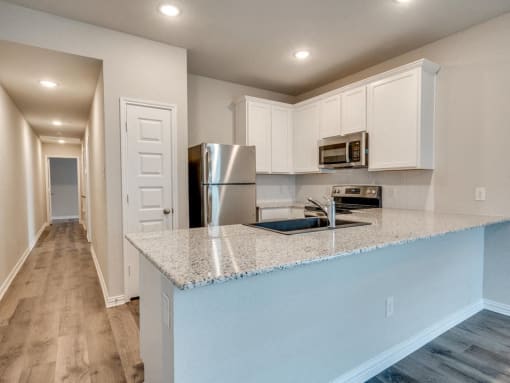a kitchen with a counter top and a stainless steel refrigerator