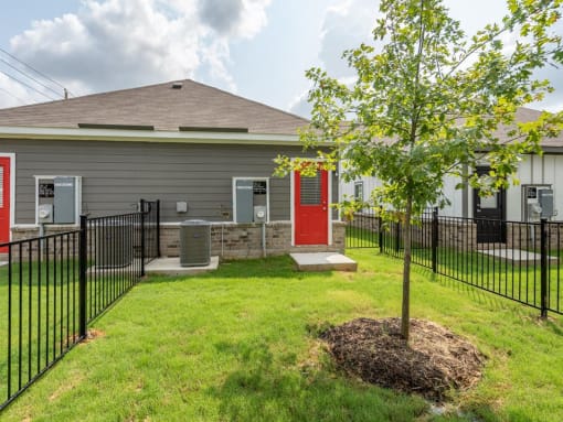 the front of a house with a yard and a tree