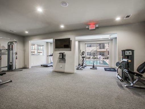 a gym with exercise equipment and a television in a building