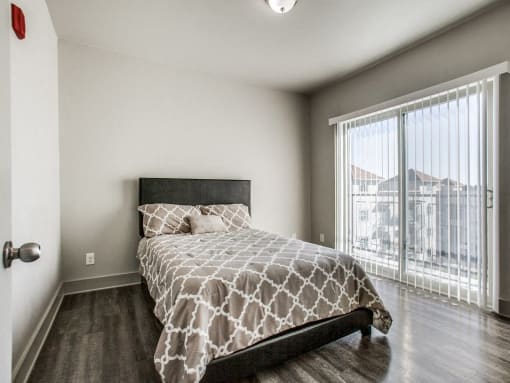 a bedroom with a large window and a bed