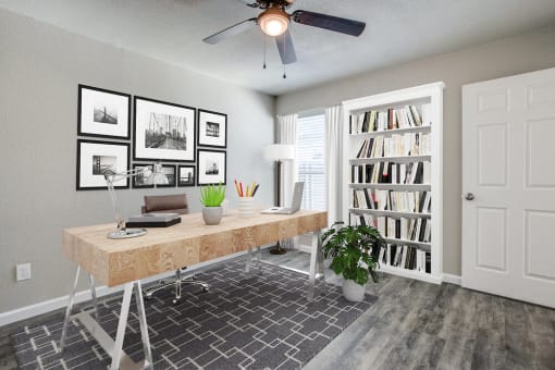 an office with a desk and a ceiling fan