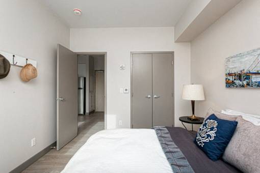 A bedroom with a bed, a lamp, and a painting on the wall.
