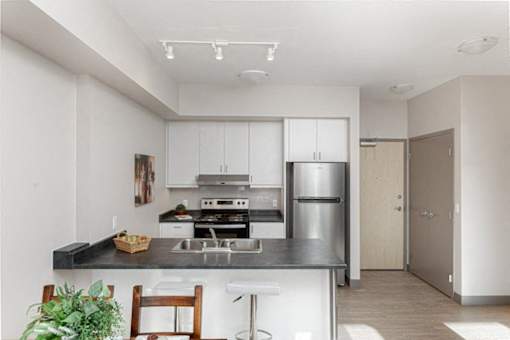 A modern kitchen with stainless steel appliances and a wooden countertop.