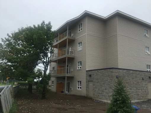 a large apartment building with a tree in front of it