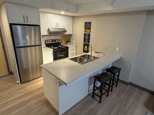 A kitchen with a stainless steel refrigerator and a white countertop.