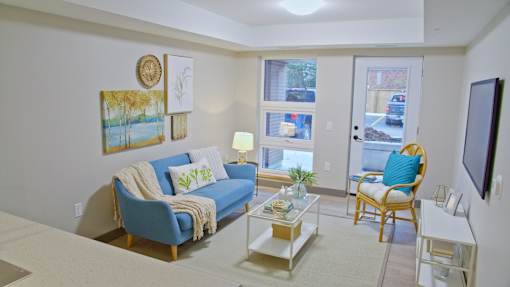 A living room with a blue couch and a white coffee table.