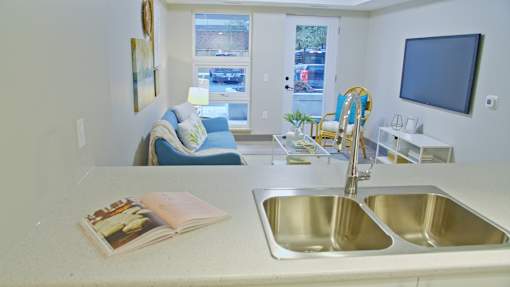 A kitchen with a sink, a book, and a window.