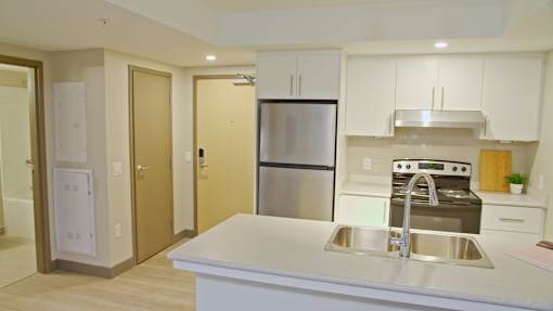 A kitchen with a sink, stove, and refrigerator.