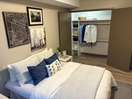 A bedroom with a white bed and a city map on the wall.