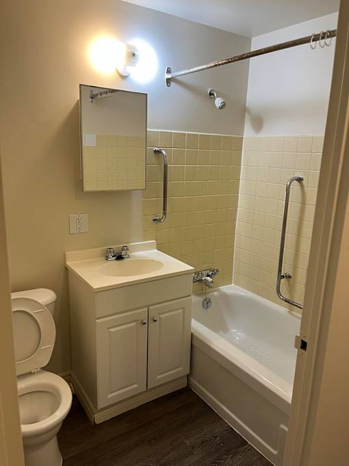 A white toilet sits next to a sink in a small bathroom.