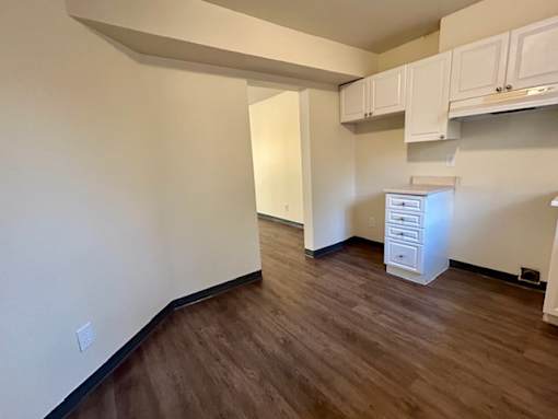 an empty living room with a hard wood floor