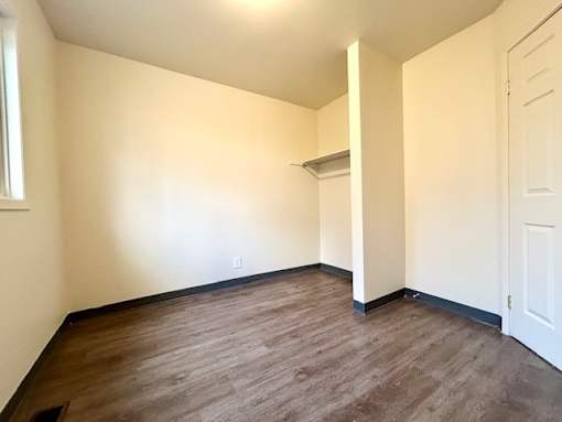 a empty room with a wood floor and white walls