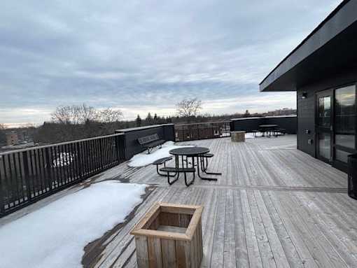 A deck with a table and chairs covered in snow.