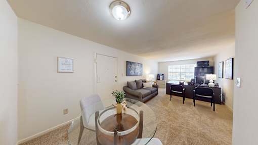 A living room with a couch, chairs, and a coffee table.