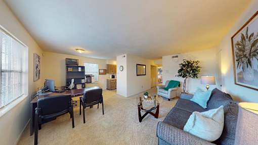 A living room with a grey couch and a brown coffee table.