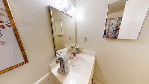 A small white sink with a grey towel on it.