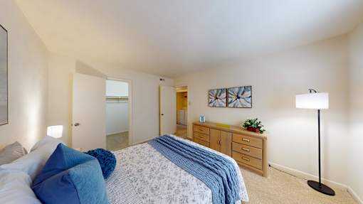 A bedroom with a bed, nightstand, and lamp.