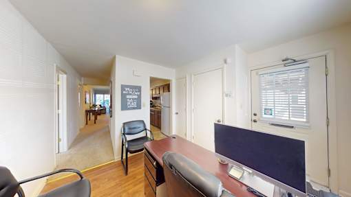 A room with a desk and a chair in it.