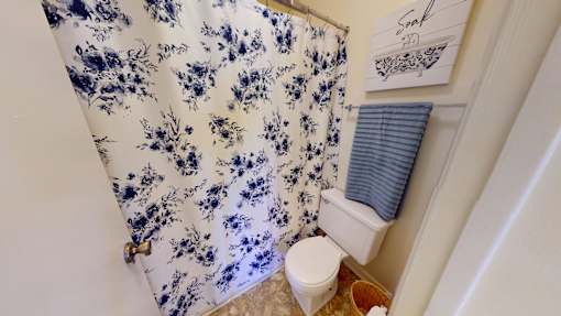 A blue and white floral shower curtain in a bathroom.