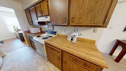 A kitchen with wooden cabinets and a stove top oven.