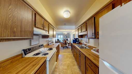 A kitchen with wooden cabinets and a white refrigerator.