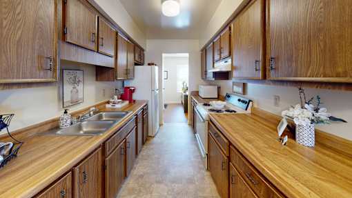 a galley style kitchen with a refrigerator and stove