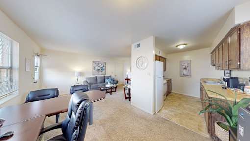 a carpeted dining space and tiled kitchen