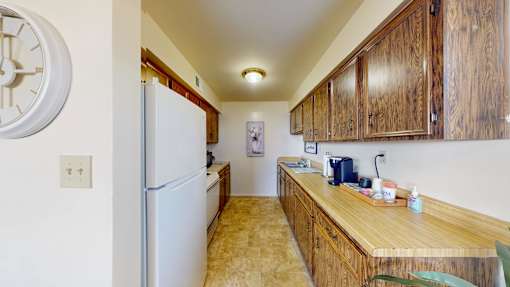 a kitchen with wooden cabinets and a refrigerator