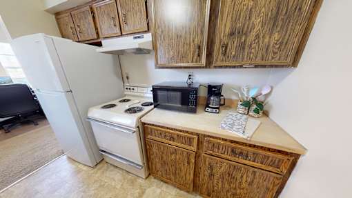 A kitchen with wooden cabinets and a white refrigerator.