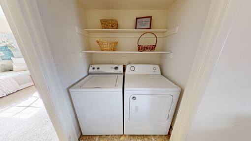 A white washing machine and dryer in a small laundry room.