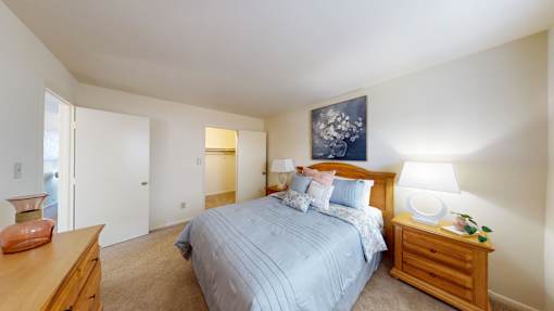 A bedroom with a bed, nightstand, and lamp.