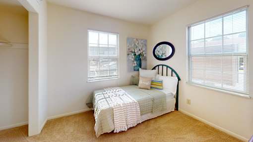 a bedroom with windows and a walk-in closets