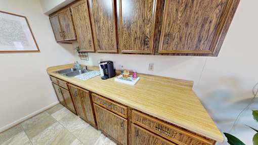 A kitchen with wooden cabinets and a wooden counter top.