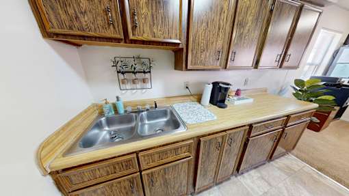 A kitchen with wooden cabinets and a double sink.