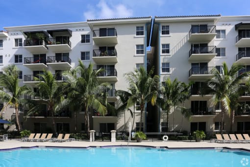 a large swimming pool in front of an apartment building