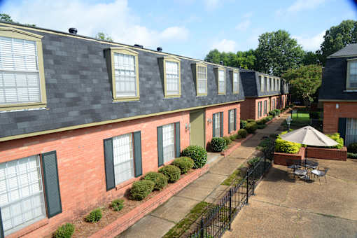 A long building with green bushes in front.